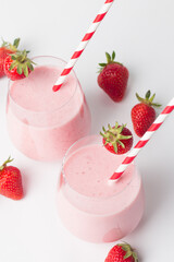 A glass of fresh strawberry smoothie on a white background. Summer drink shake, milkshake and refreshment organic concept.