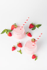 A glass of fresh strawberry smoothie on a white background. Summer drink shake, milkshake and refreshment organic concept.