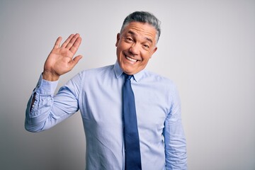 Middle age handsome grey-haired business man wearing elegant shirt and tie Waiving saying hello happy and smiling, friendly welcome gesture