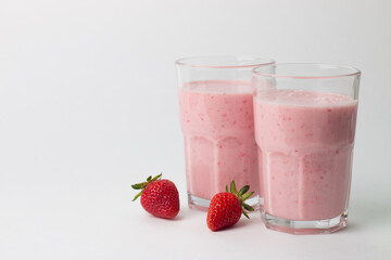 A glass of fresh strawberry smoothie on a white background. Summer drink shake, milkshake and refreshment organic concept.
