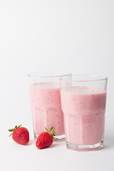A glass of fresh strawberry smoothie on a white background. Summer drink shake, milkshake and refreshment organic concept.