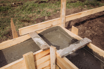 Filling concrete in a wooden box, building the foundation of an apartment building, shovel in concrete