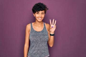 Young beautiful african american afro sportswoman doing exercise wearing sportswear showing and pointing up with fingers number three while smiling confident and happy.