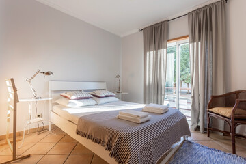 Fototapeta na wymiar Modern bedroom with a large window. European hotel design.
