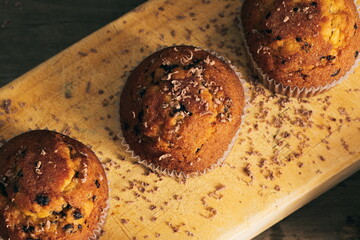 still life of muffins with chocolate shavings on wooden board