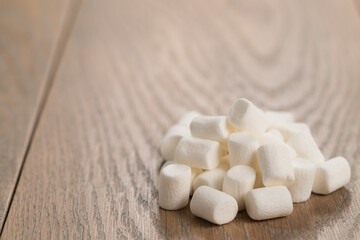 Fototapeta na wymiar small white marshmallows pile on wooden background