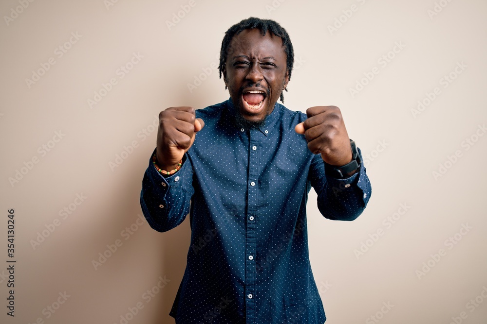 Poster young handsome african american man wearing casual shirt standing over white background angry and ma