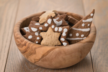 Gingerbread chrismas cookies in olive bowl on oak wood background with copy space