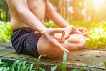Close up hands. Asian man do yoga relax outdoor. Man exercising pose vital and meditation for fitness lifestyle club at the outdoors nature background.