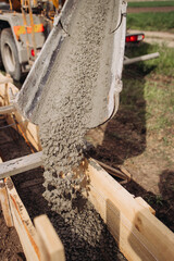 Filling concrete in a wooden box, building the foundation of an apartment building, shovel in concrete