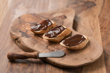 sweet breakfast baguette with chocolate hazelnut spread on wood board