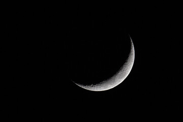 Fototapeta na wymiar Waxing crescent moon against a black night sky viewed in the northern hemisphere
