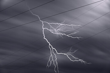 Stromleitungen mit Blitz vor dramatischem Himmel