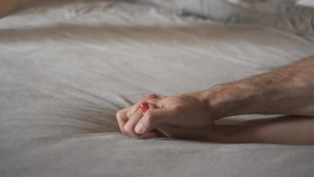Holding hands before sex. couple Sensual touch on bed sheet. foreplay games and hookup. love