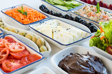 Traditional Turkish Breakfast Table with cheese,olives,fruits,patty,tomato and jam on the white surface.Buffet style