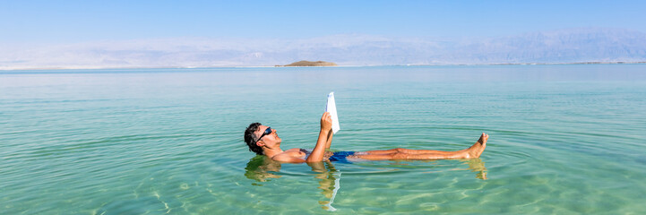 Man relaxing in nature.. View of Dead Sea coastline. Salt crystals at sunset. Texture of Dead sea....