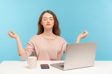 Peaceful mind, break at work. Calm woman employee sitting at workplace with laptop and raising...