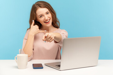 Hey you, call me! Beautiful lovely woman employee sitting at workplace with laptop and pointing to...