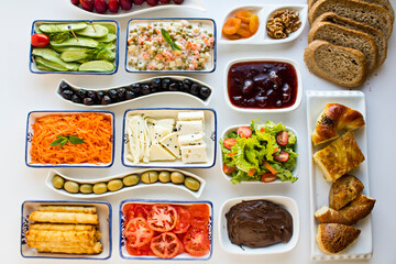 Traditional Turkish Breakfast Table with cheese,olives,fruits,patty,tomato and jam on the white surface.Buffet style