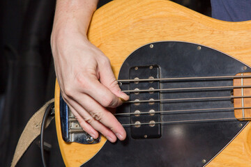 Mediator technique of playing with the right hand on a five string electric bass guitar