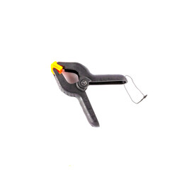 Construction clamp, clothespin, Black plastic clip with red tips isolated on white background.