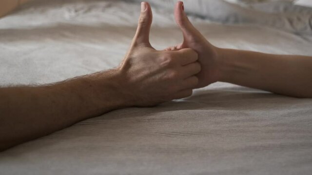 Thumb war game on bed.  Close up of hands playing thumb war. Sensual couple game. foreplay 