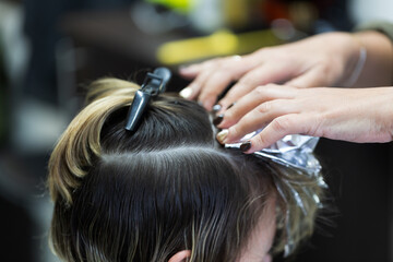 hairdresser cutting hair of a woman