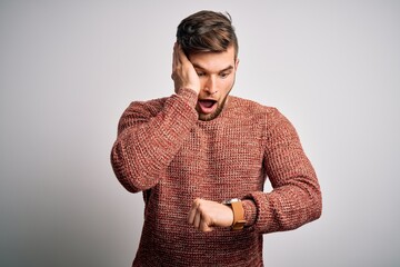 Young blond man with beard and blue eyes wearing casual sweater over white background Looking at...