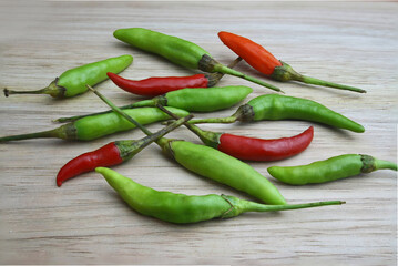 red hot chili peppers on wooden table, red and green , orange spicy chili , vegetable for healthy living  , good ingredient for cooking 