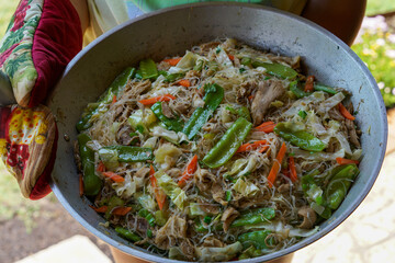Holding a Filipino dish, homemade Pansit Bihon