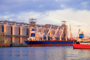 Bulk carrier ship in river port. Dry cargo grain elevator trade. Agrarian maritime facility. Cargo...