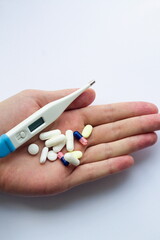 Pills and thermometer in hand