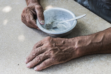 Hungry. Poor old man's hands an empty bowl. Selective focus. Poverty in retirement. Alms - obrazy, fototapety, plakaty
