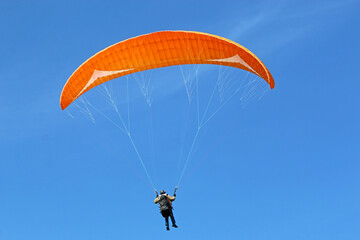Paraglider flying wing in a blue sky	