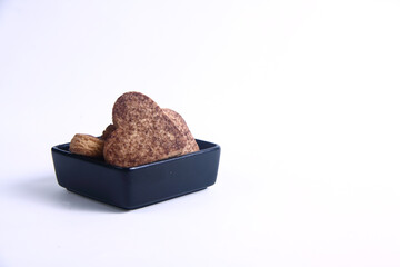 heart shaped cookies in black bowl isolated on white background