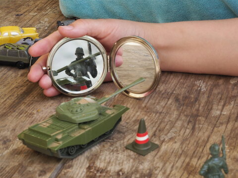 Children's toys military tank and soldier on a wooden background. Children's toys military tank and soldier on a wooden background close up