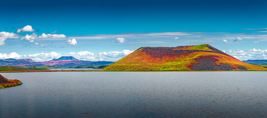 Panoramic view of colorful pseudo craters and volcanoes near Skutustadir town at lake Myvatn in Iceland, summer, blue sky with clouds