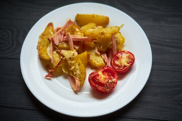 Baked potatoes with bacon, cheese and tomatoes in a plate.
