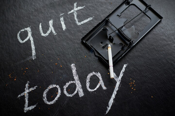 Stop smoking today concept. Mousetrap with cigarettes and the inscription- Quit today.