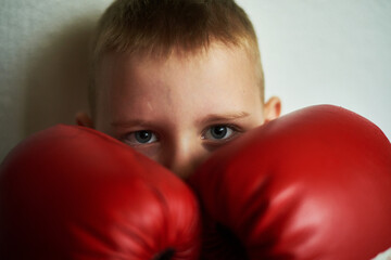 The boy closes with boxing gloves.