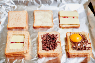 Making sandwiches from toast bread with minced meat, egg and cheese. Different stages of the calculation of the ingredients.
