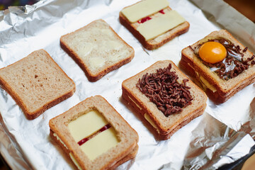 Making sandwiches from toast bread with minced meat, egg and cheese. Different stages of the calculation of the ingredients.