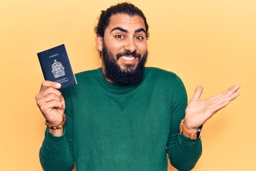 Young arab man holding canada passport celebrating achievement with happy smile and winner...