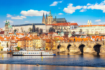 Fototapeta na wymiar Prague Castle, Charles bridge, Mala Strana district and sightseeing touristic ship during summer sunny day in Prague, Czech Republic.