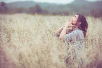 Flowers and the woman palm in the field. Lit evening sun.