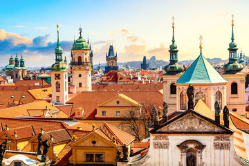 Houses and churches with traditional red roofs in the center of Prague, Czech Republic during sunset