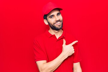 Young handsome man with beard wearing casual polo and cap smiling cheerful pointing with hand and...