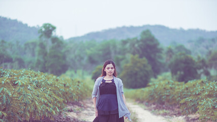 Carefree happy woman enjoying nature on the street with grass meadow and sunrise.