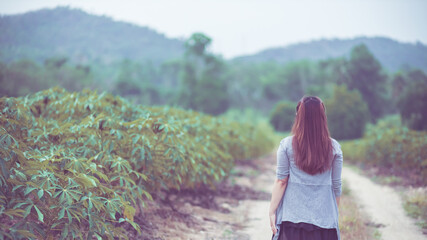 Naklejka premium Carefree happy woman enjoying nature on the street with grass meadow and sunrise.