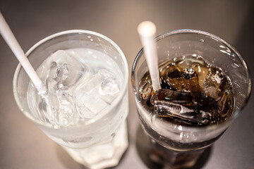 Glasses of sweet carbonated drinks with ice cubes.